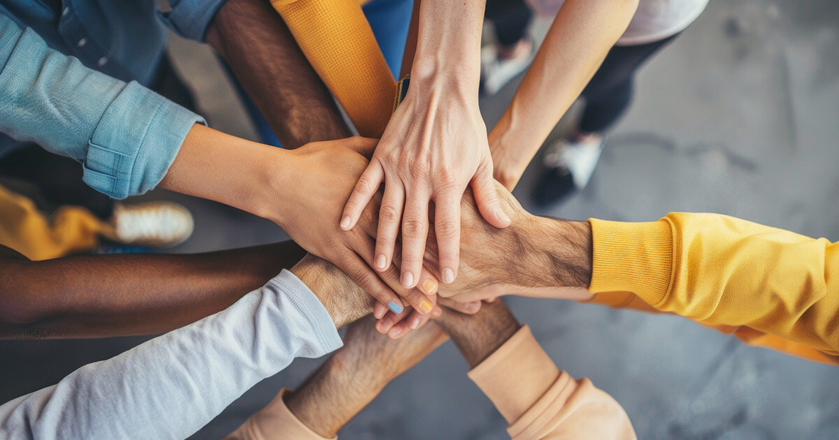 group of team members with hands stacked showing alignment